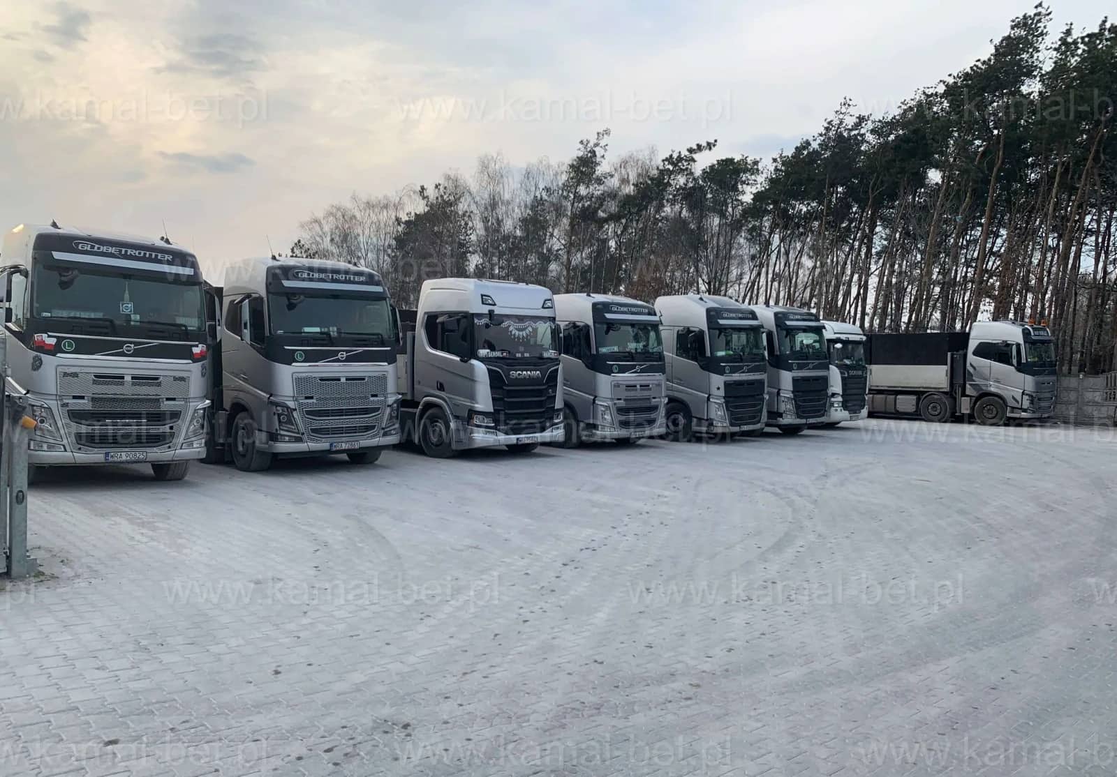 Flota Kamal-Bet — rząd ciągników siodłowych Volvo i Scania zaparkowanych na placu firmowym