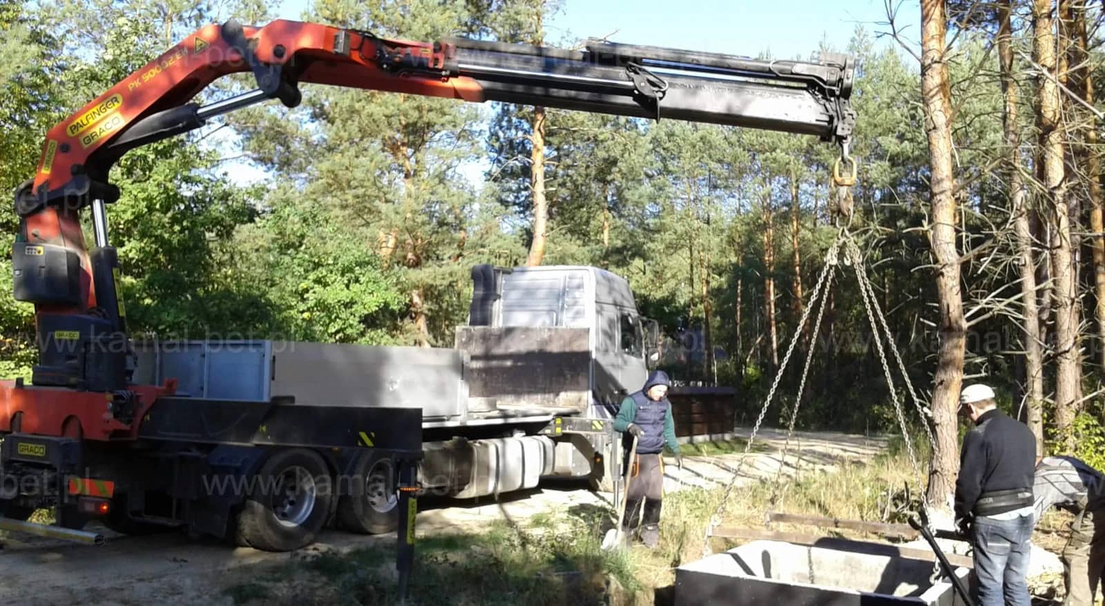 Samochód z żurawiem HDS rozładowujący betonowy zbiornik na działce klienta