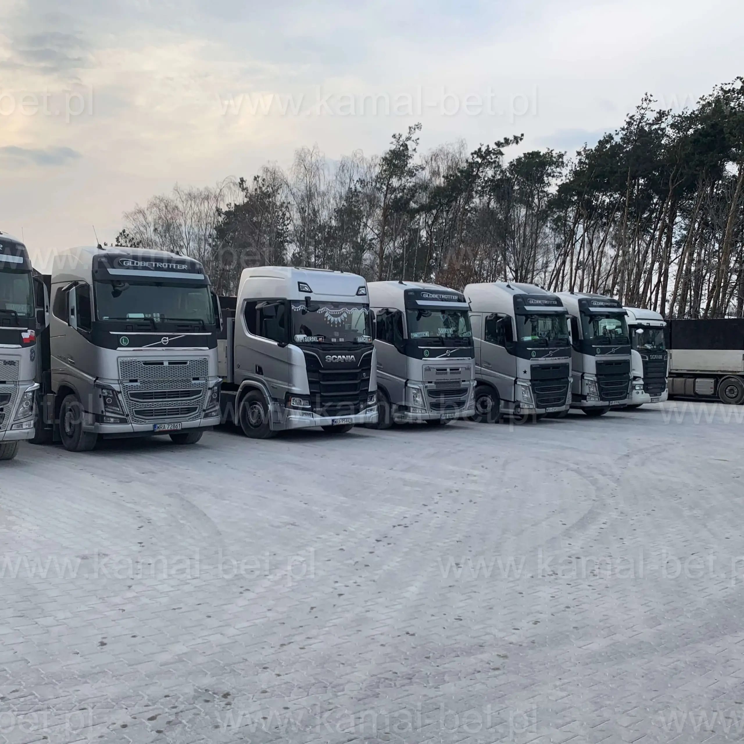 Flota Kamal-Bet — rząd ciągników siodłowych Volvo i Scania zaparkowanych na placu firmowym