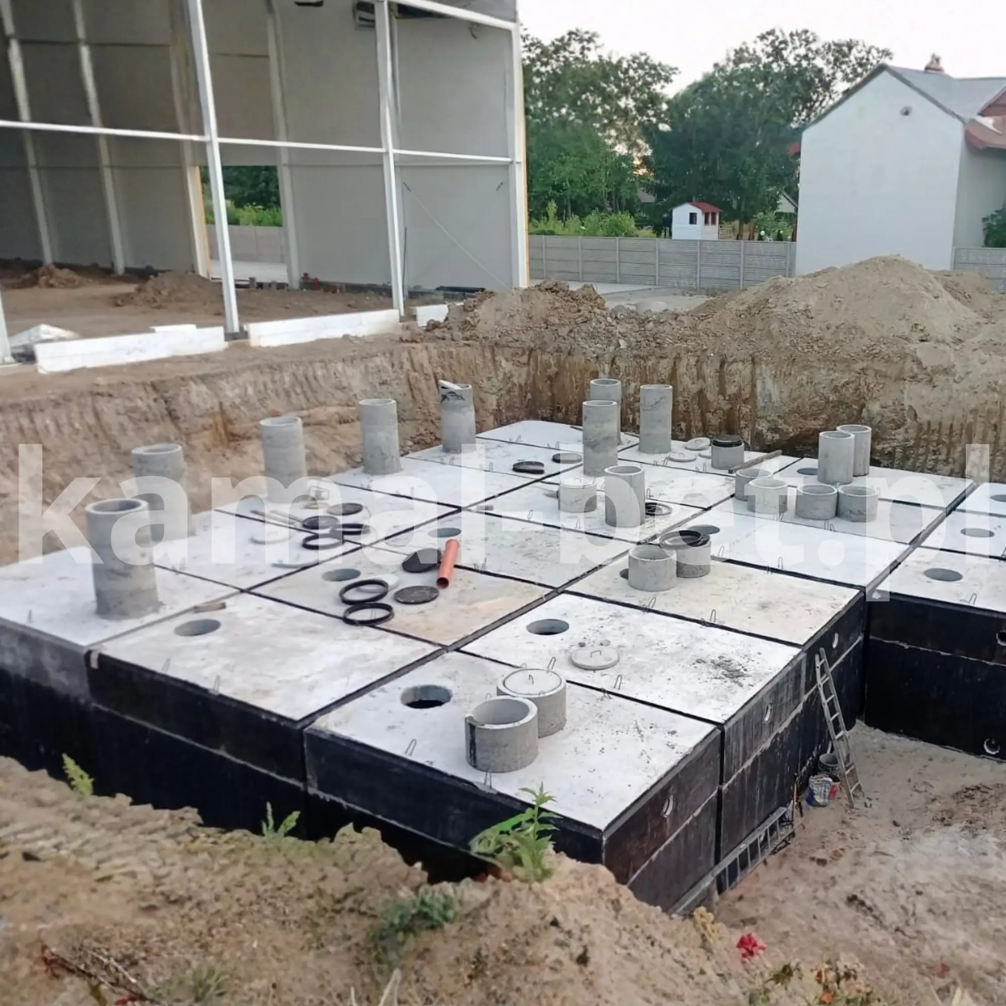 Bateria zbiorników betonowych z kominami włazowymi w trakcie montażu