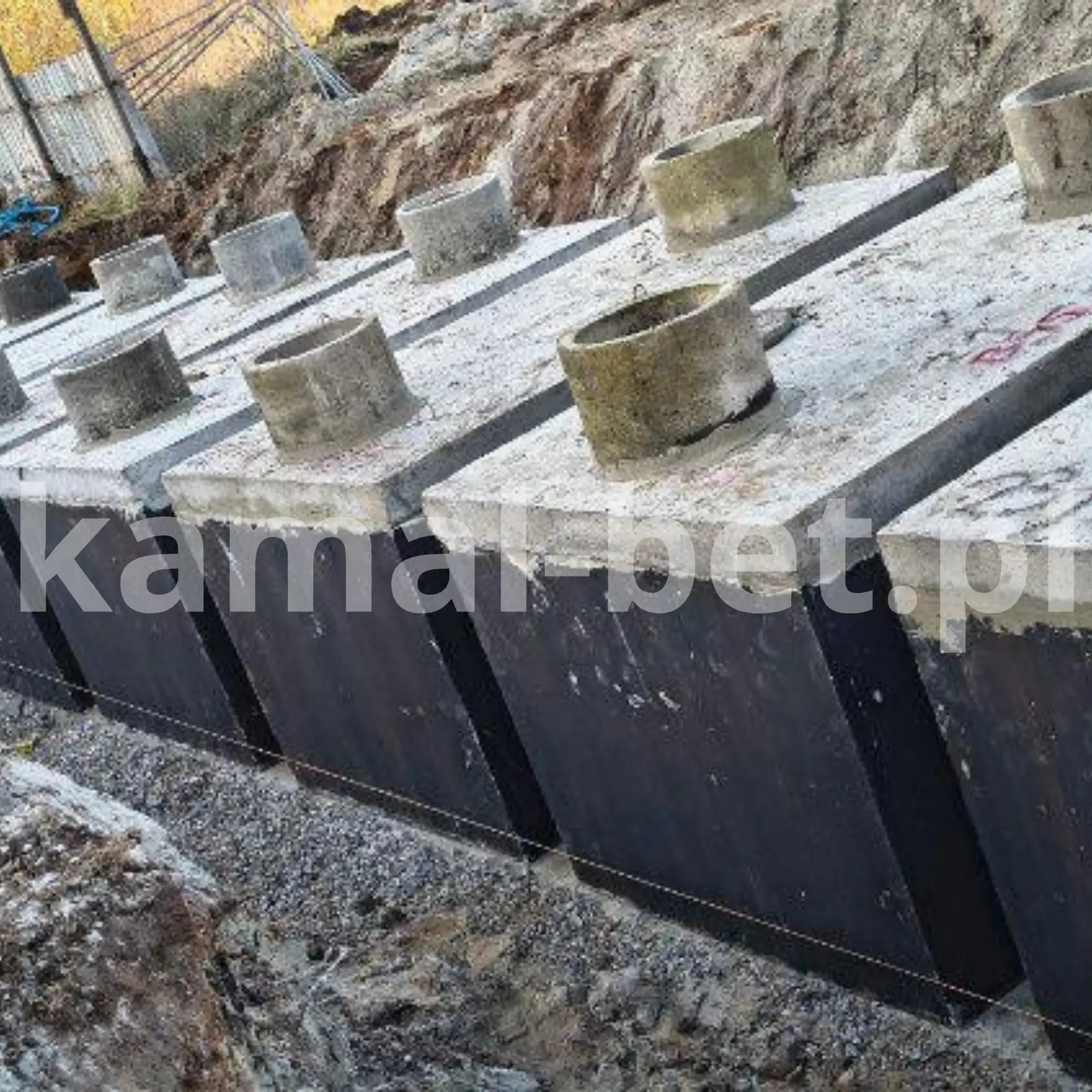 Szereg zbiorników betonowych z kominami w wykopie